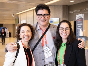 A man and two women smiling during refreshment break at ISHLT2024