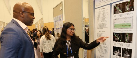 A speaker at ISHLT2023 explains a poster presentation to another attendee