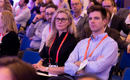 Two attendees watch a session at ISHLT2024