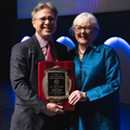 Simon Urschel stands with Lori West with her Lifetime Achievement Award plaque