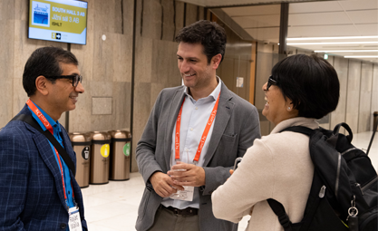 Three attendees gather in a circle