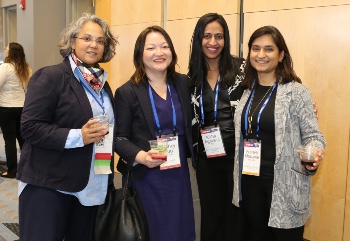 Four women standing and smiling