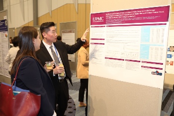 Two people examining a poster presented at ISHLT2023