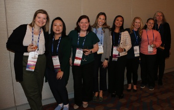 Eight women posing for a photo and smiling