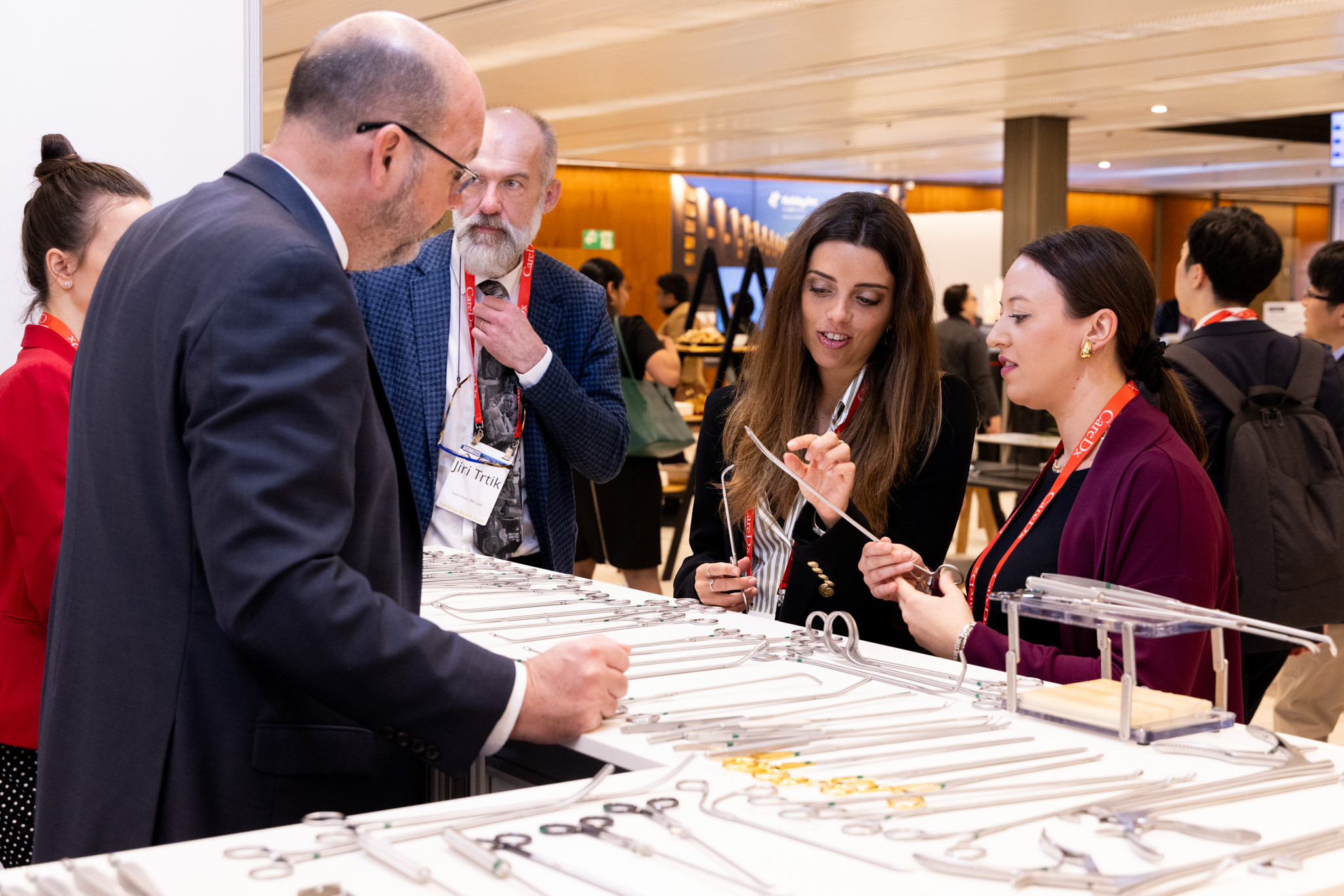 Two women explore medical tools at a ISHLT2024 exhibit booth